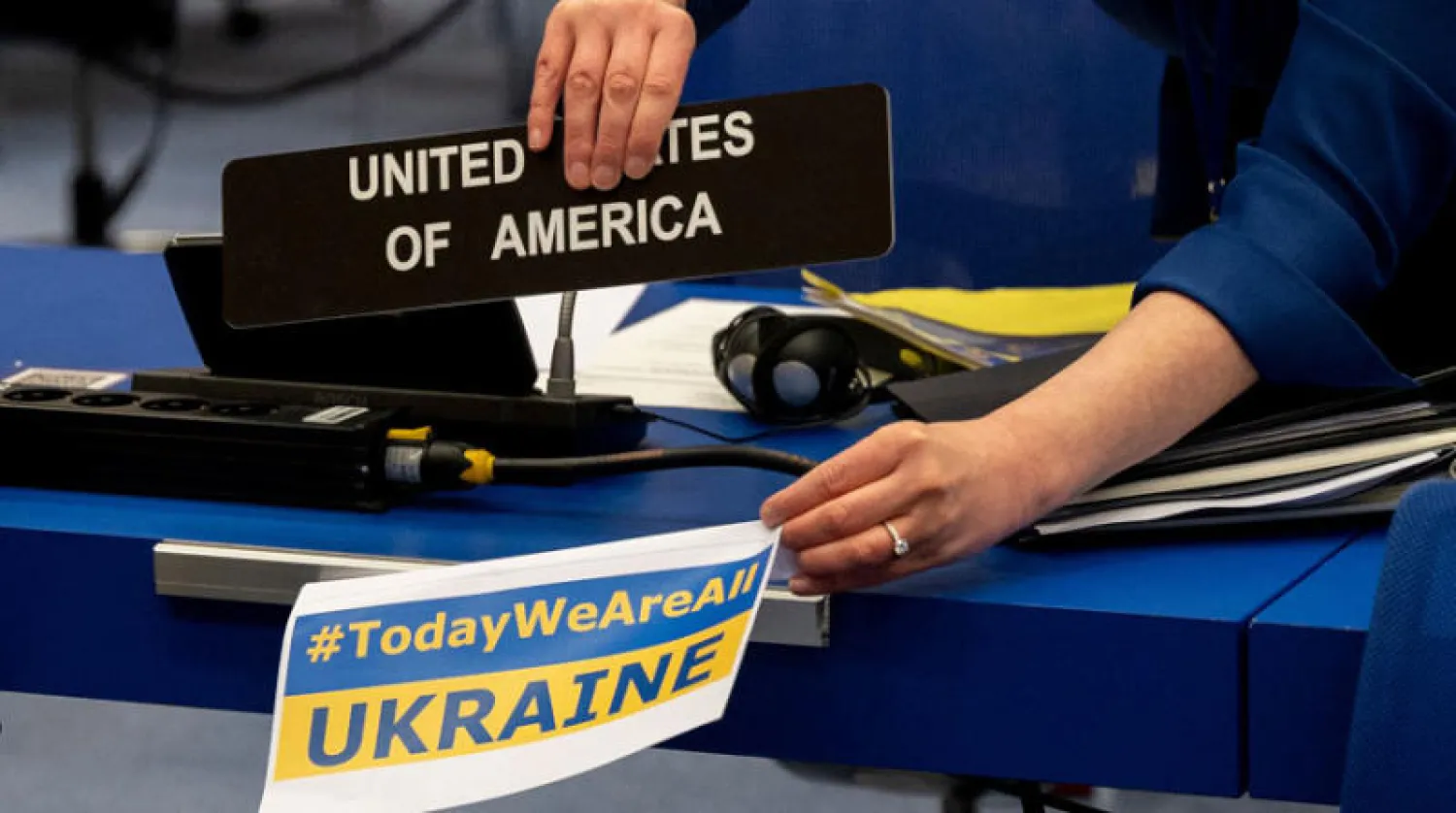 عضو في وفد الولايات المتحدة لوكالة الطاقة الدولية خلال اجتماع المنظمة في فيينا يضع اسم أوكرانيا بدلاً من أميركا على مقعده تضامناً مع كييف (أ.ف.ب)