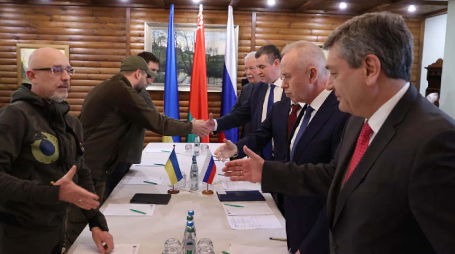 الوفدان الروسي والأوكراني يتصافحان قبل انطلاق الجولة الثانية من المفاوضات أمس (إ.ب.أ)