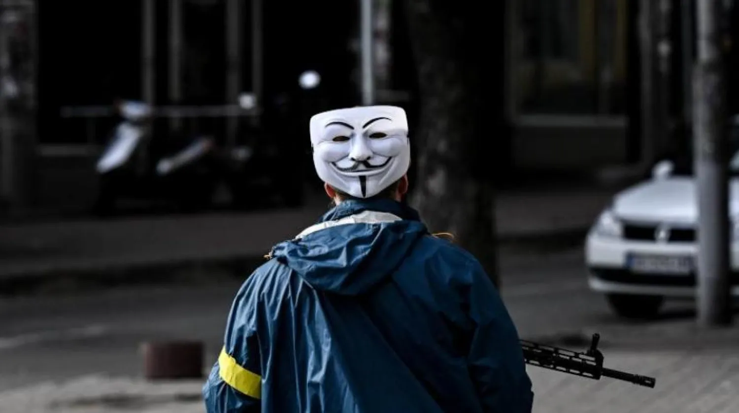 Ukrayna kuvvetlerinin bir üyesi, Anonymous ile bağlantılı bir maske takıyor (AFP)