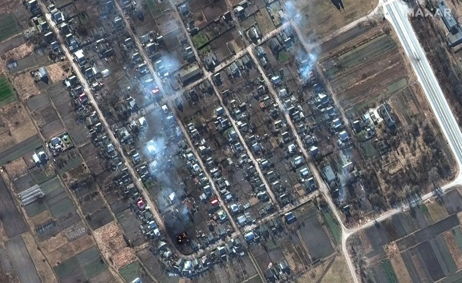This satellite image provided by Maxar Technologies shows a closer view of burning homes and impact craters in a field in Rivnopillya, Ukraine on Feb. 28, 2022. (Satellite image ©2022 Maxar Technologies via AP)