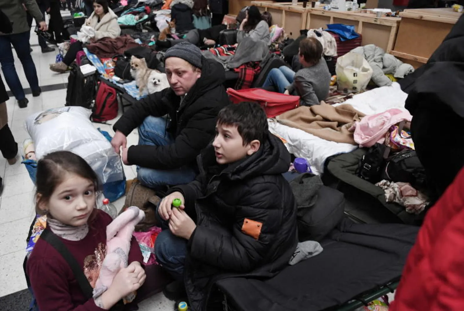 أوكرانيون في مخيم لاستقبال اللاجئين عند الحدود الأوكرانية البولندية (رويترز)