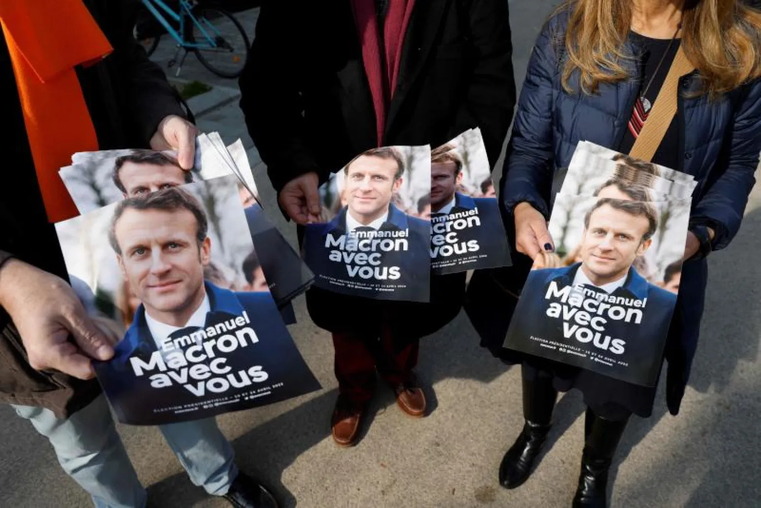 ناشطون يوزعون مناشير مؤيدة للرئيس إيمانويل ماكرون في باريس (أ.ف.ب)