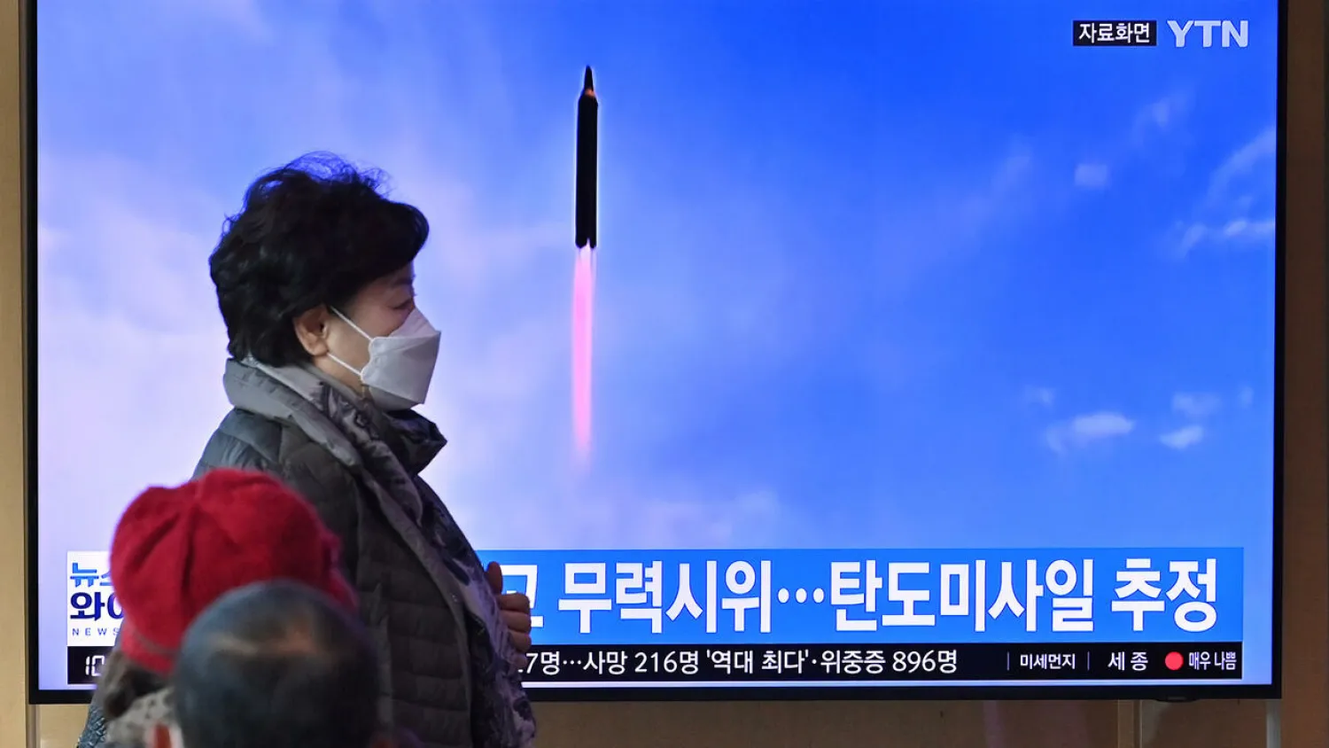 People watch a news broadcast with file footage of a North Korean missile test, at a railway station in Seoul on March 5, 2022 Jung Yeon-Je. AFP
