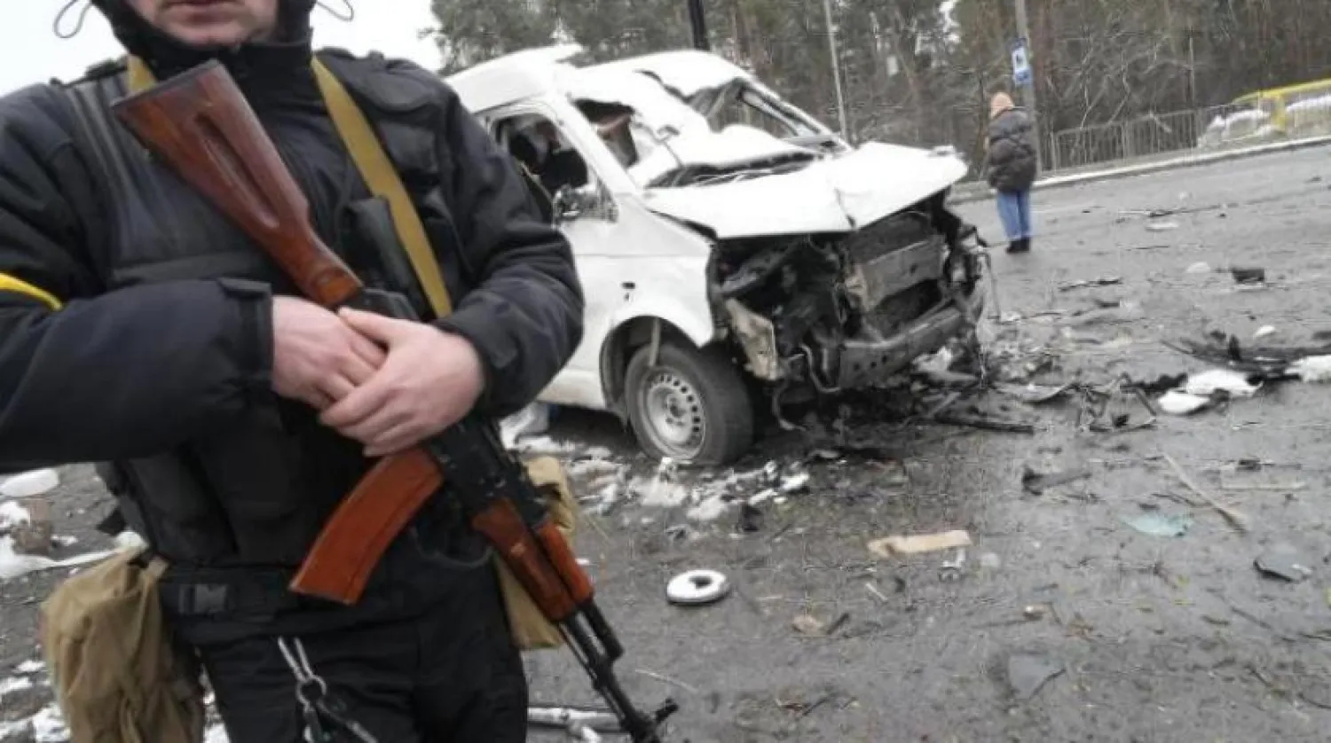 مرد مسلح كنار خودروی نظامی منهدم شده در ایست بازرسی در شهر برواری نزدیک کی یف (آرشیو- آسوشیتد پرس) 