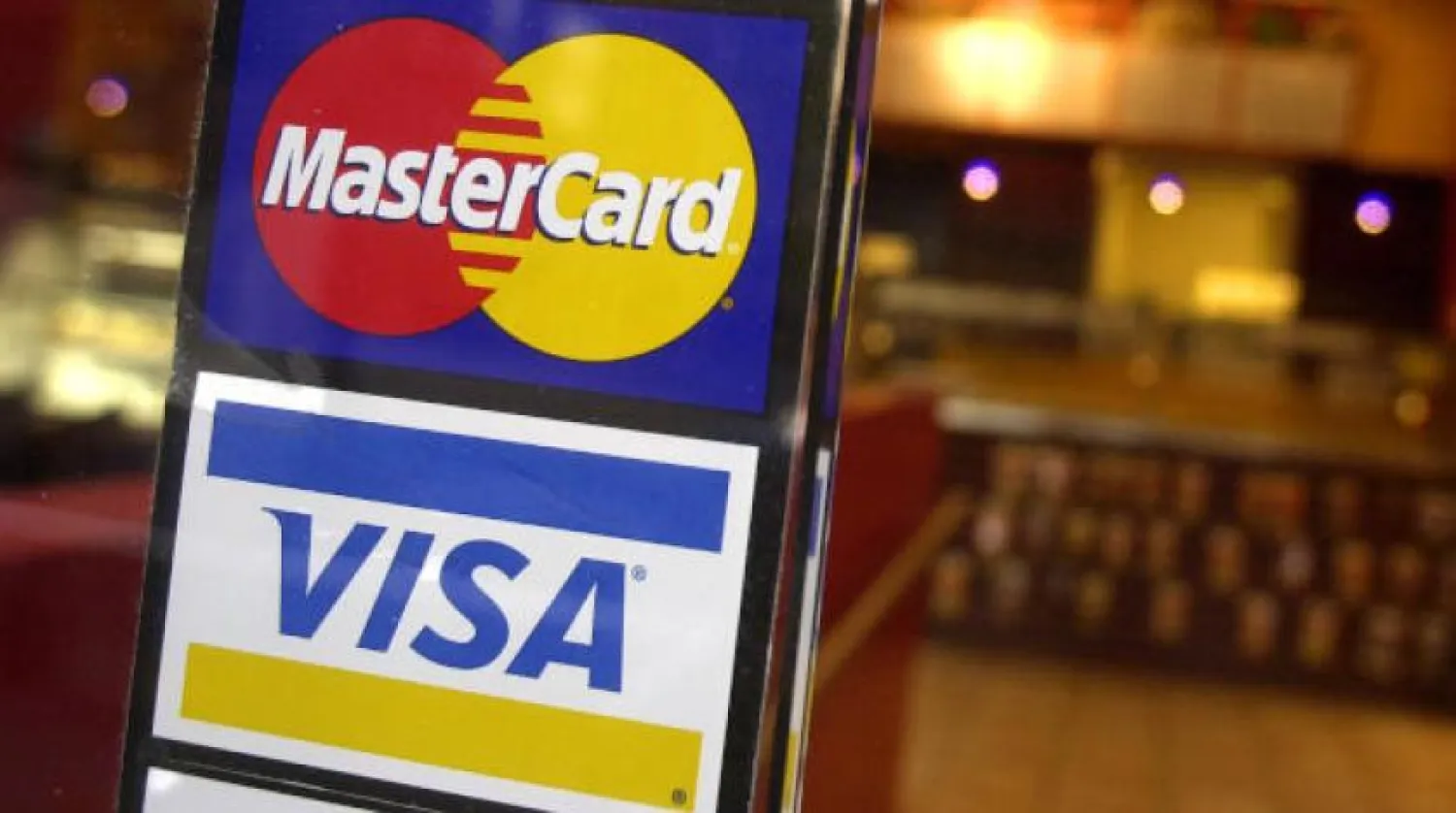 Visa and MasterCard logo displayed at the entrance to a café in New York (AP)