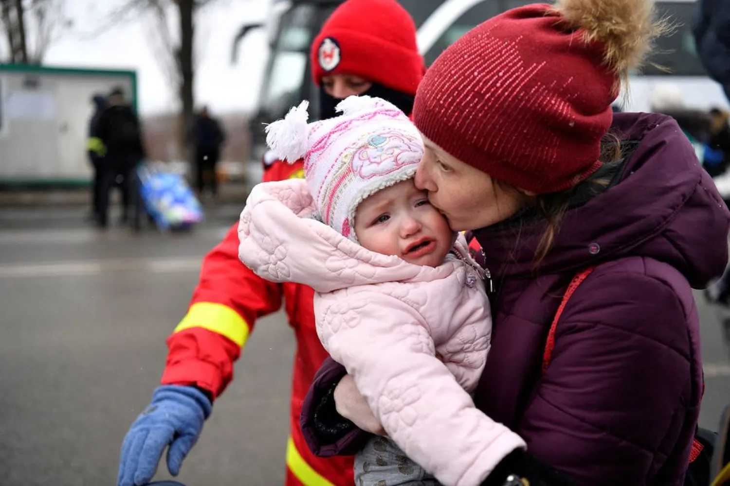 A woman kisses her baby after fleeing from Ukraine to Romania, following Russia's invasion of Ukraine, at the border crossing in Siret, Romania, March 7, 2022. (Reuters)