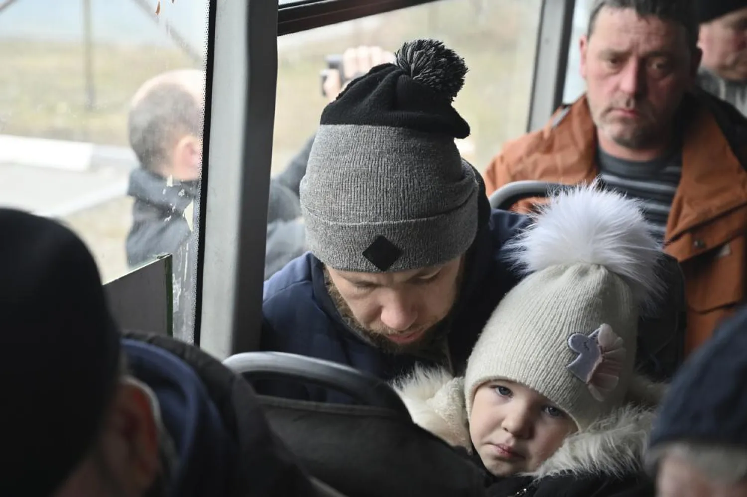 Refugees fleeing fleeing the military operation zone from the Mariupol area of Ukraine sit in a bus as they arrive at the border crossing in Veselo-Voznesenka, Russia, Monday, March 7, 2022. (AP)