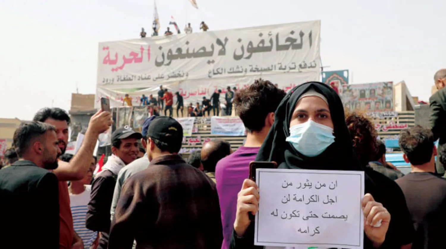 محتجة عراقية على غلاء الأسعار في مدينة الناصرية أمس (أ.ف.ب)