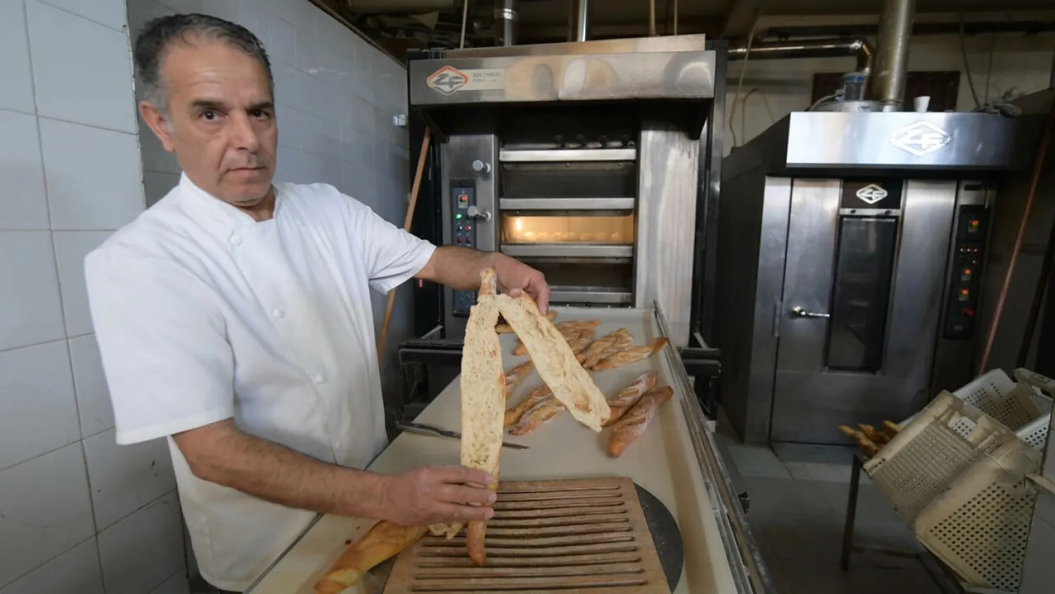 Master baker Taoufik inspects bread at his bakery in the El Menzah area of the Tunisian capital. (AFP)