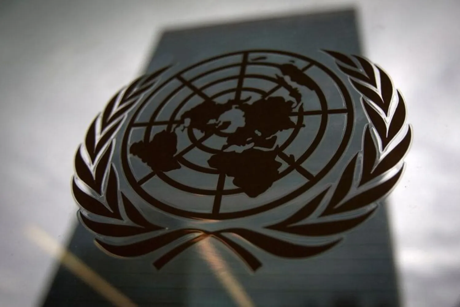 The United Nations headquarters building is pictured though a window with the UN logo in the foreground in the Manhattan borough of New York August 15, 2014.. (Reuters)