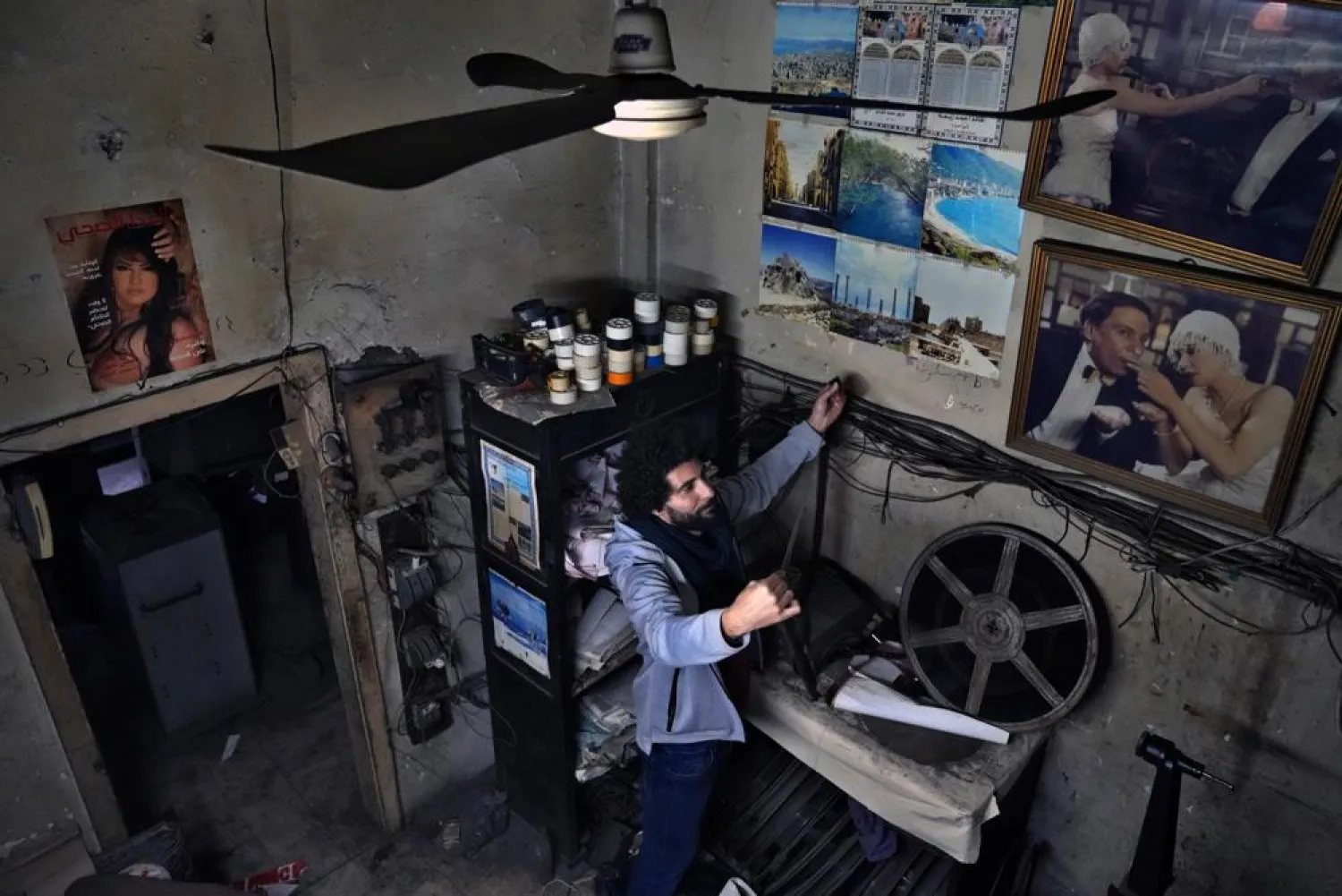 Kassem Istanbouli, actor, director and founder of the Tyro Association for Arts, inspects a film at Empire Cinema in Tripoli, Lebanon, Feb. 16, 2022. (AP Photo/Bilal Hussein)
