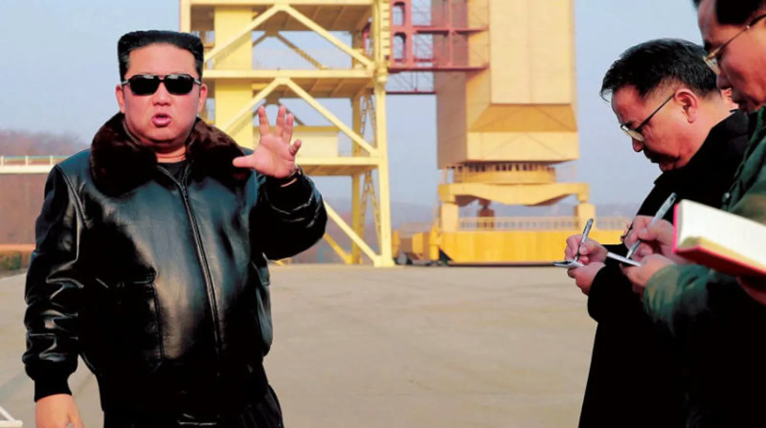 صورة غير مؤرخة نشرتها وكالة الأنباء المركزية الكورية الشمالية تظهر كيم جونغ أون (إلى اليسار)  يتحدث مع مسؤولين خلال زيارة إلى موقع إطلاق القمر الصناعي في تشولسان بمقاطعة بيونغان الشمالية (د.ب.أ)