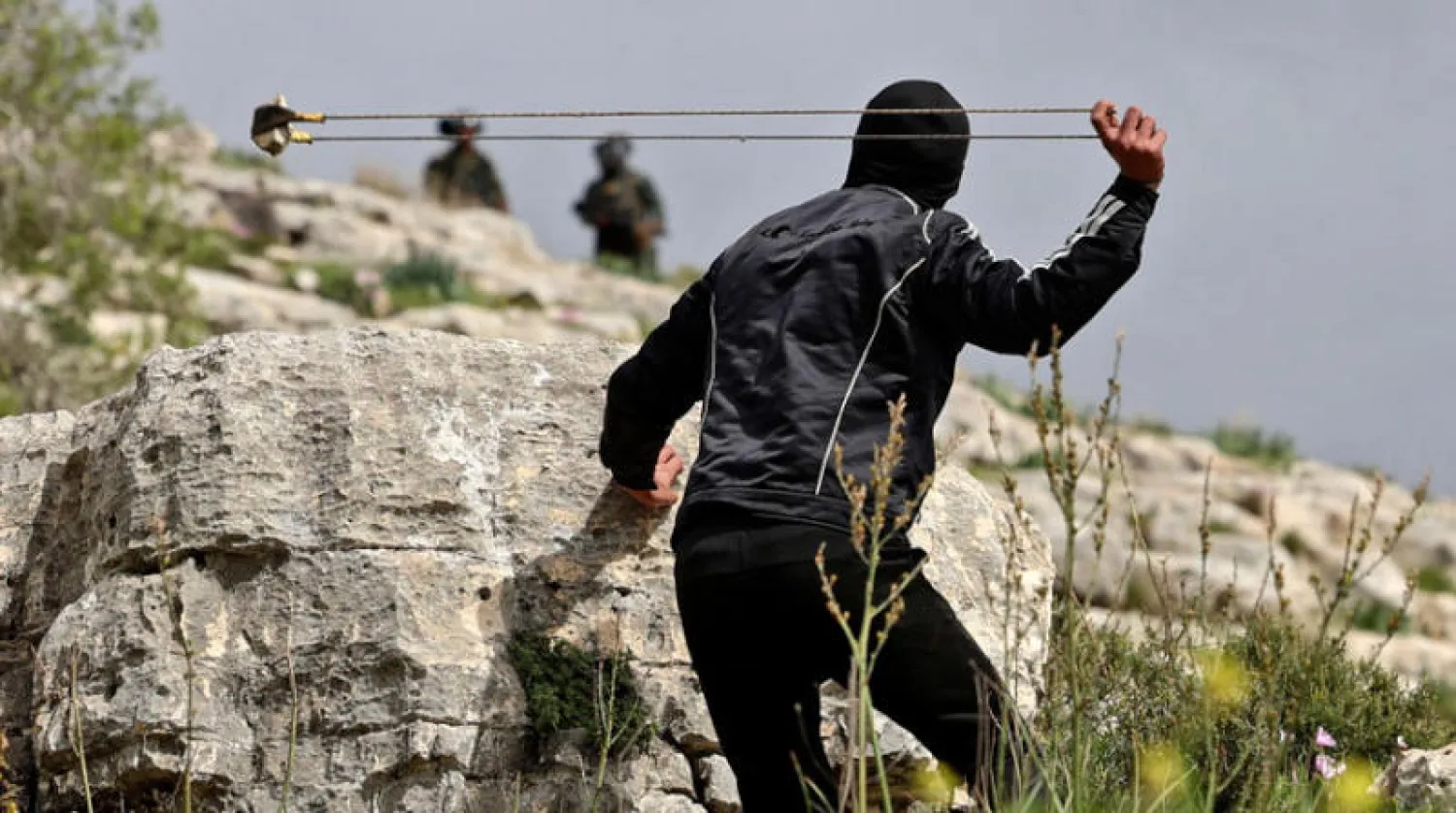 فلسطيني خلال مواجهات مع قوات إسرائيلية ضد سياسة مصادرة الأراضي في قرية كفر قدوم بالضفة (أ.ف.ب)