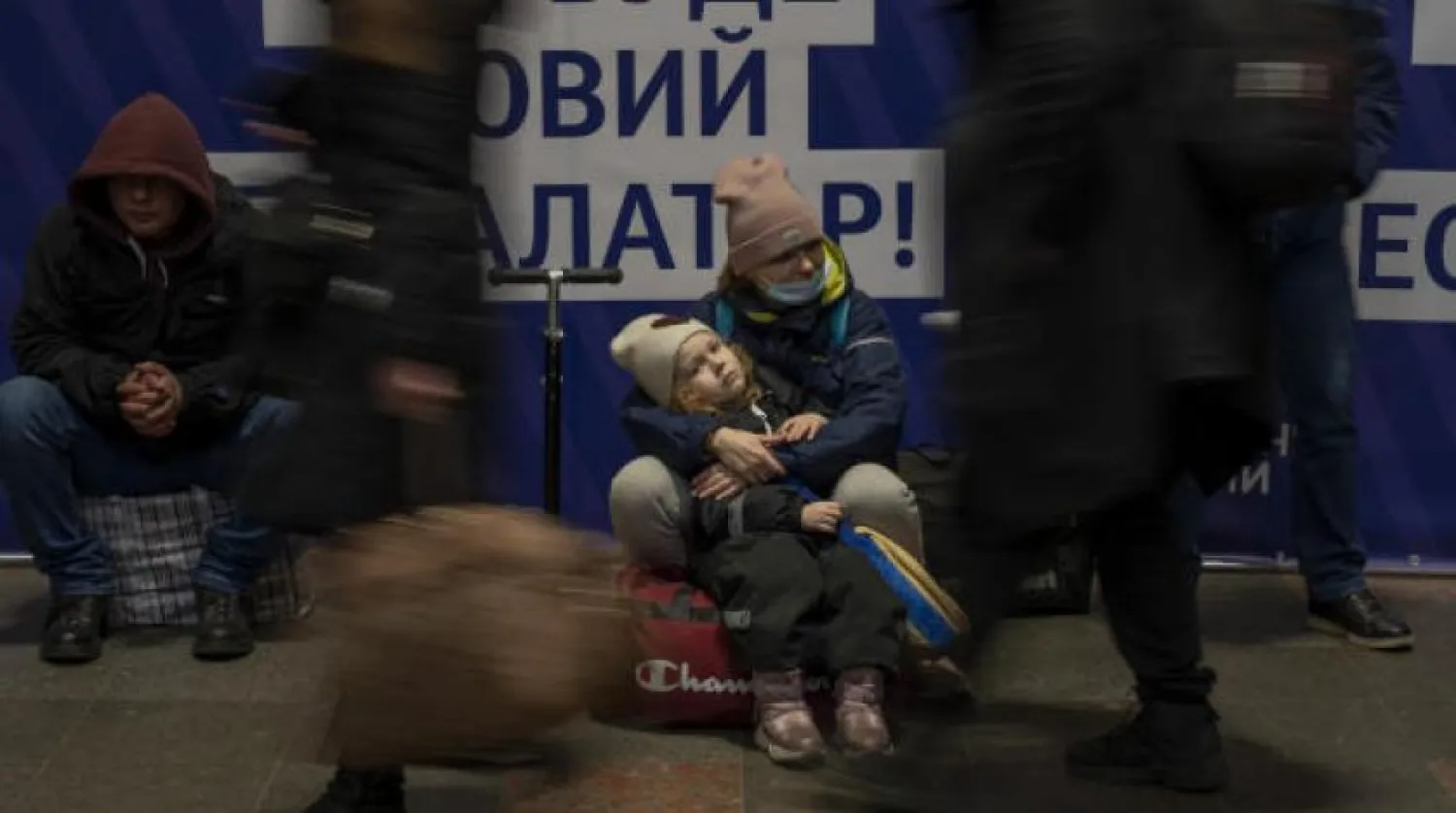 A woman with her daughter waits for a train as they try to leave at the Kyiv train station, Ukraine, Thursday, Feb. 24, 2022. AP
