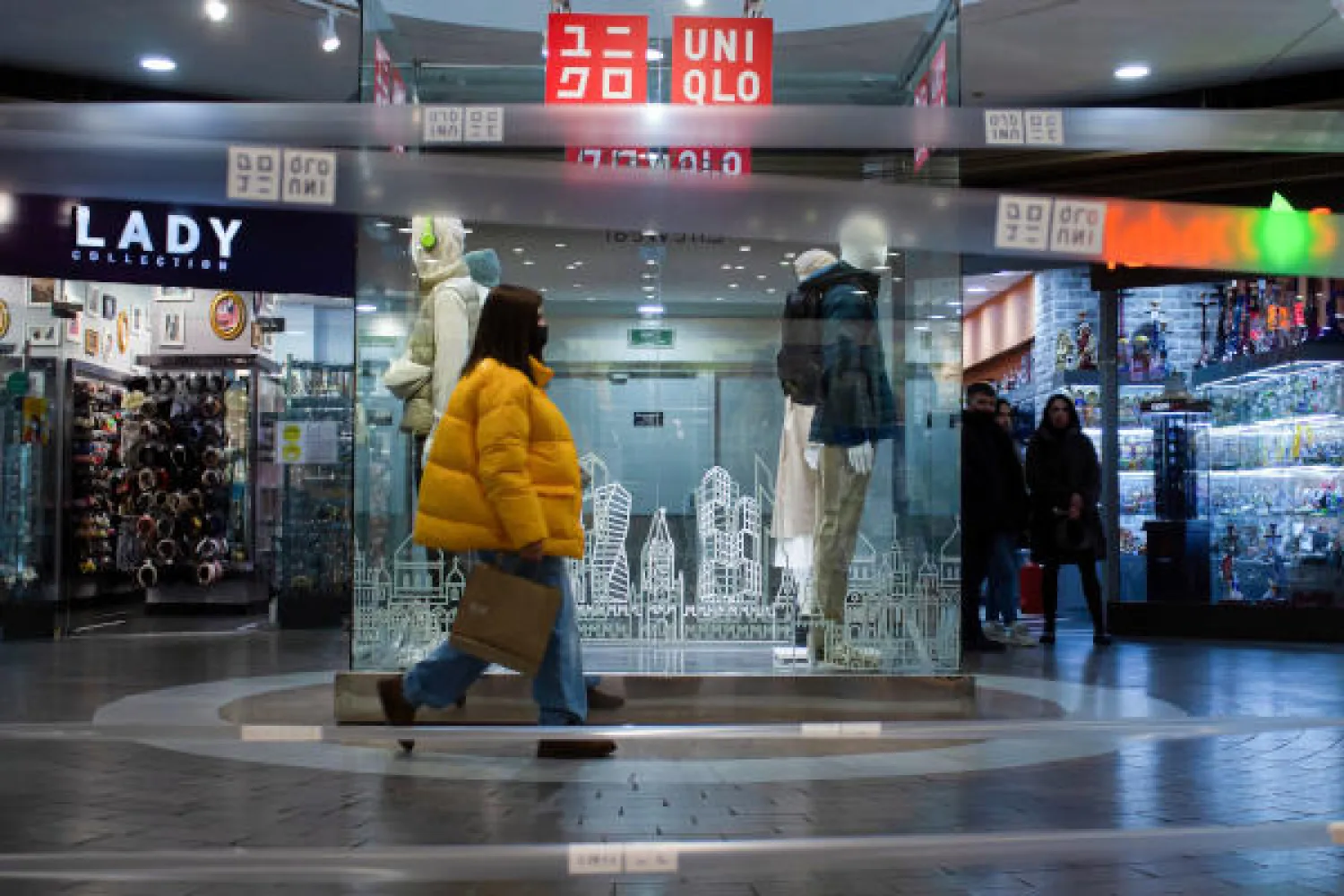 سيدة تمر بجانب متجر في موسكو (د.ب.أ)