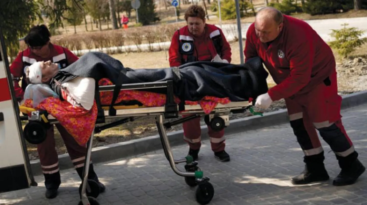 Ukrayna'nın batısındaki Novoyavorsk üssüne dün düzenlenen hava saldırısında yaralanan bir kişi hastaneye kaldırılırken. (AP)  