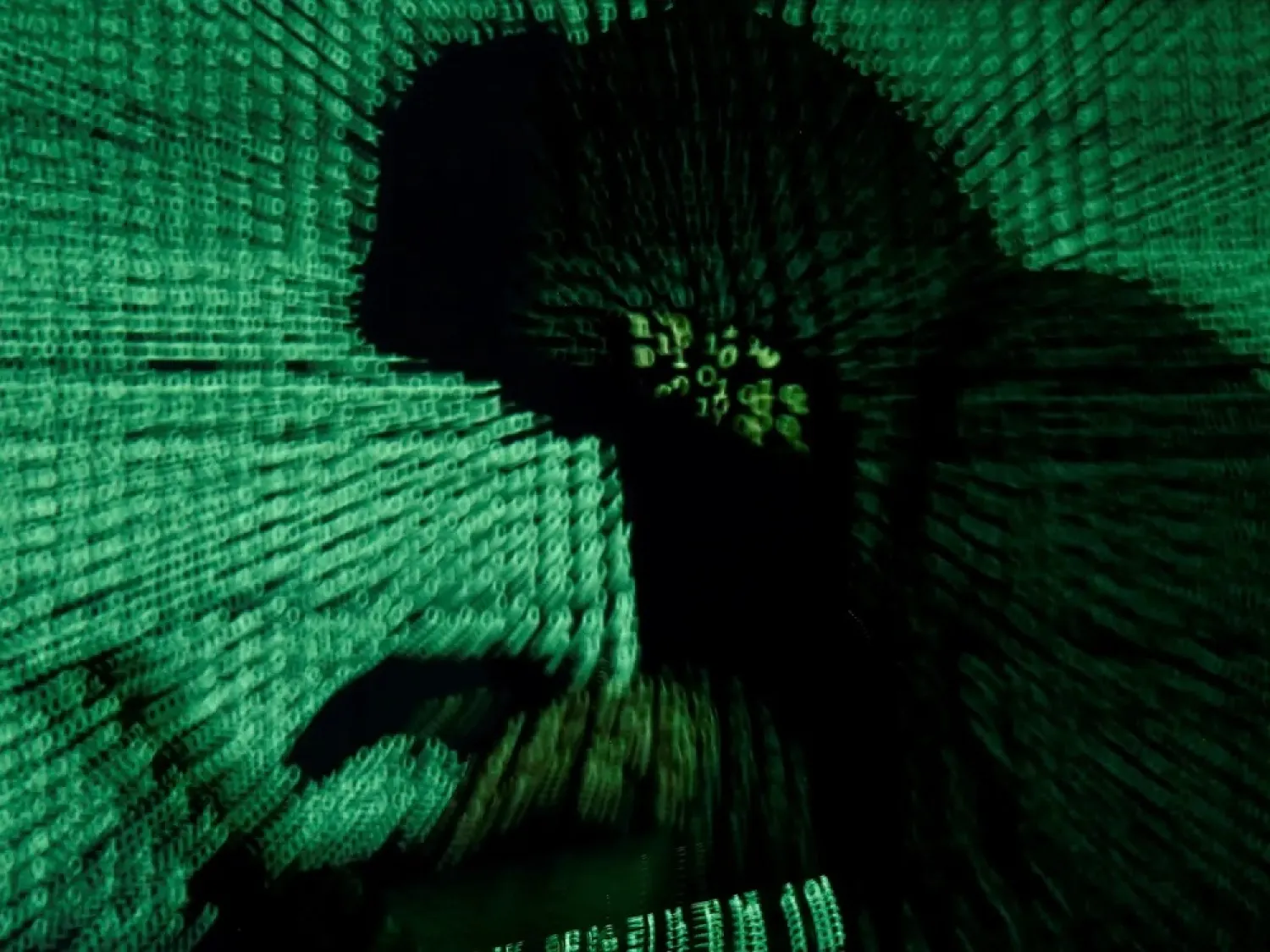 A man holds a laptop computer as cyber code is projected on him in this illustration picture taken on May 13, 2017. (Reuters)