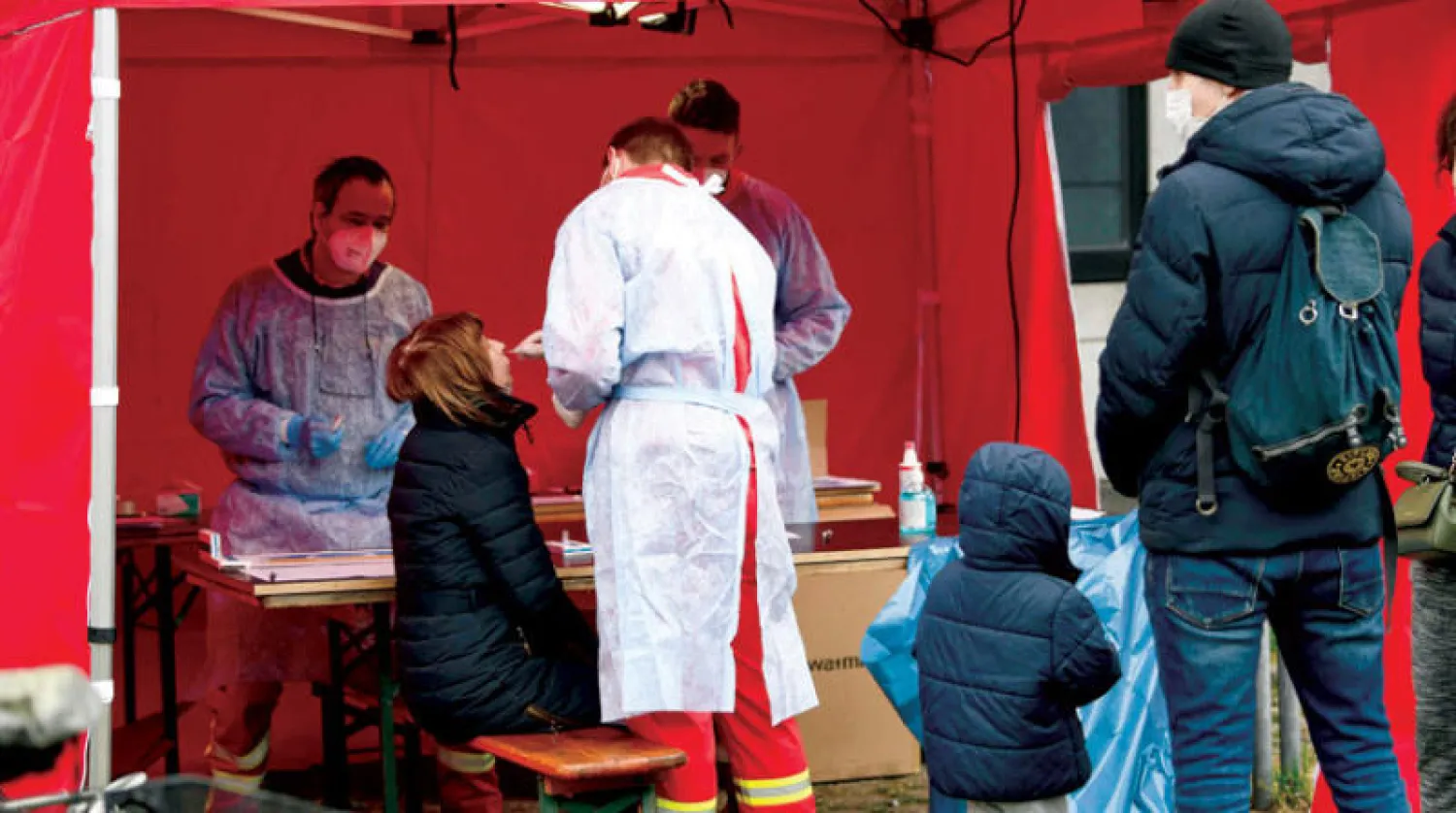 نازحون أوكرانيون يخضعون لفحص {كورونا} في ألمانيا أمس (أ.ف.ب)