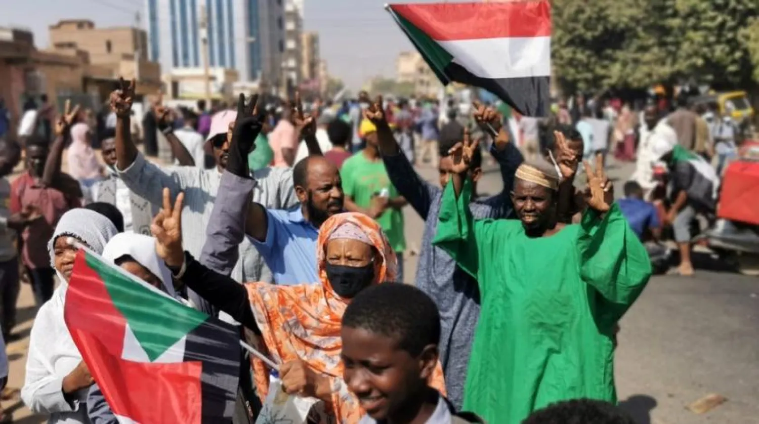 Sudanese protesters raise national flags as they protest against the October 2021 military coup, in the capital Khartoum, on January 9, 2022. (AFP)
