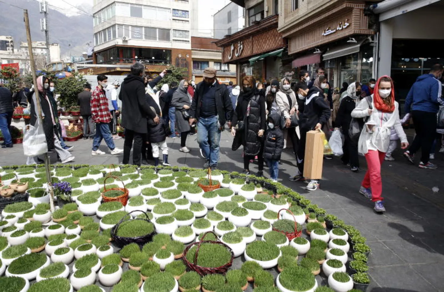 إيرانيون يتسوقون استعدادا لعيد النوروز في أحد شوارع طهران (إ.ب.أ)