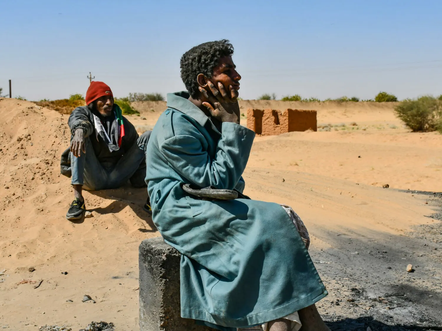People watch as protesters in northern Sudan block a key trade route between Egypt and their country following a dramatic increase of electricity tariffs - AFP
