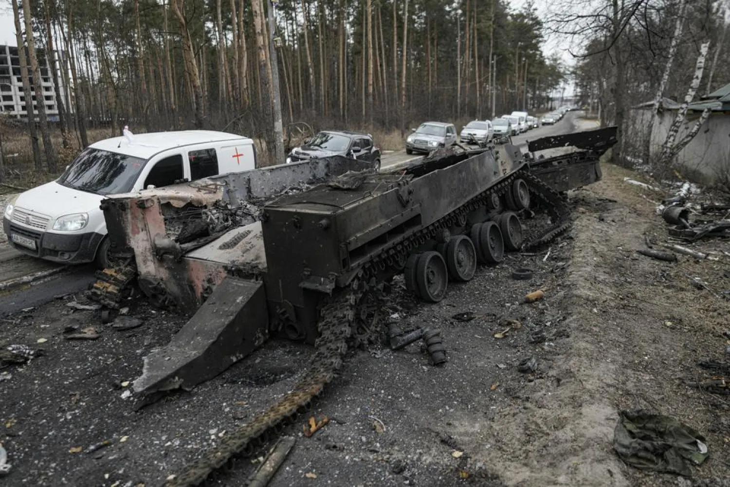 Cars drive past a destroyed Russian tank as a convoy of vehicles evacuating civilians leaves Irpin, on the outskirts of Kyiv, Ukraine, March 9, 2022. (AP)