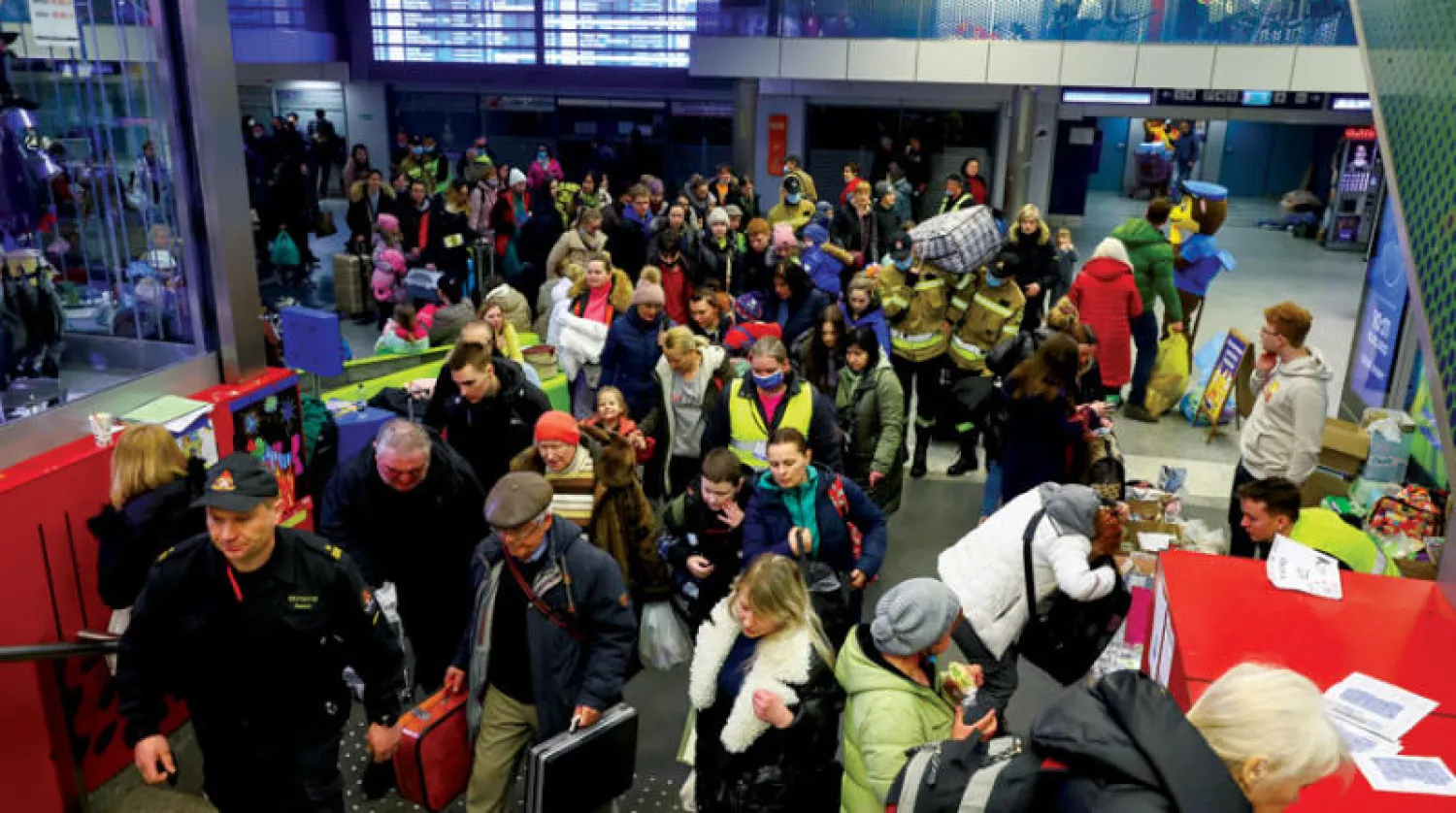 متطوعون يدلّون لاجئين متجهين نحو برلين في محطة قطار كراكوف (رويترز)