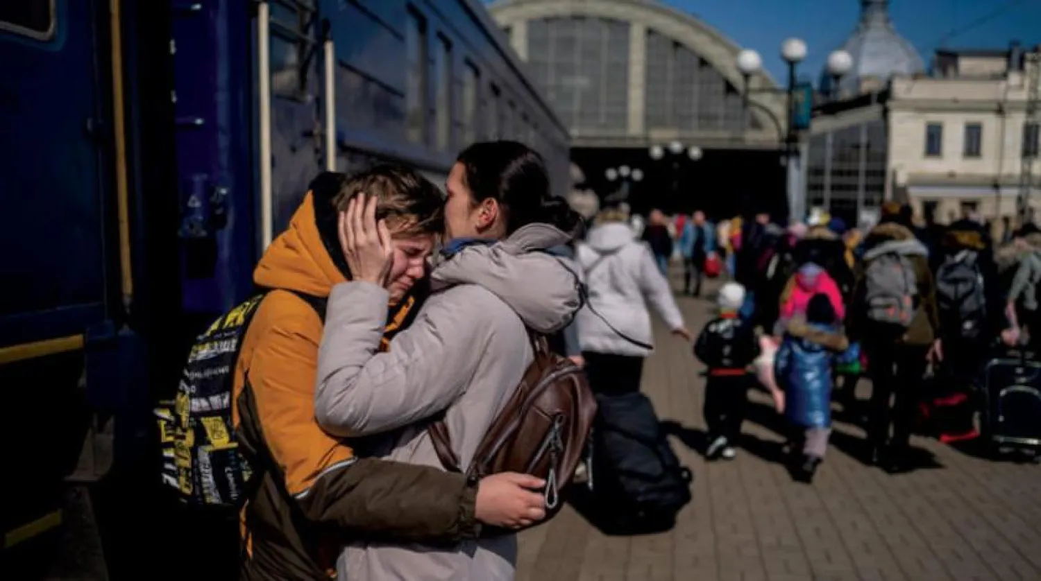Kuşatma altındaki Mariupol kentinden Lviv’e gelmeyi başaran oğluna sarılan bir anne. (AP)  