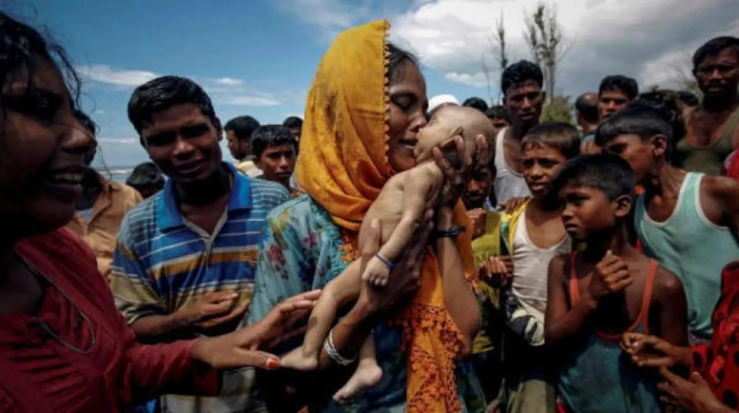 أرشيفية لامرأة من الروهينغا تحتضن رضيعها الذي توفي قبل وصول مركبهم إلى ملجأهم في بنغلاديش (رويترز)