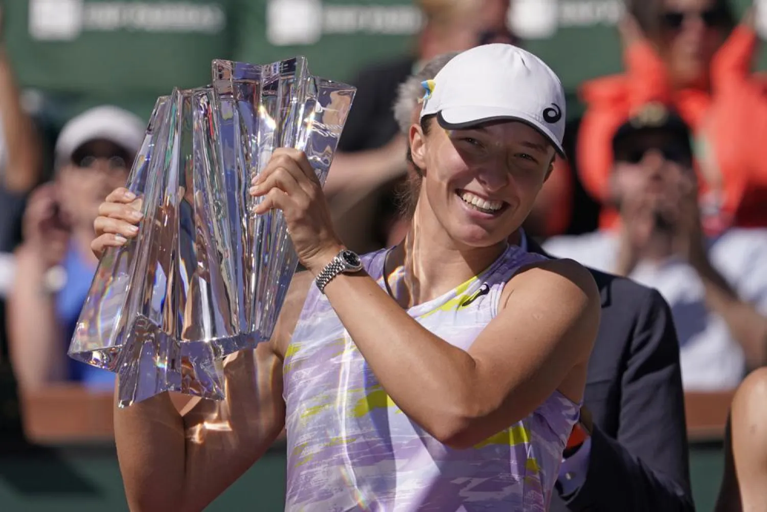 Iga Swiatek, of Poland, smiles as she holds her trophy after defeating Maria Sakkari, of Greece, in the women's singles finals at the BNP Paribas Open tennis tournament Sunday, March 20, 2022, in Indian Wells, Calif. Swiatek won 6-4, 6-1. (AP)