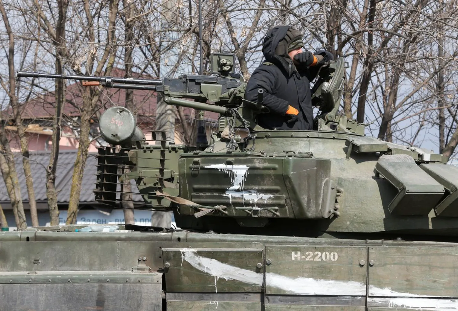 A service member of pro-Russian troops in uniform without insignia is seen atop of a tank during Ukraine-Russia conflict in the besieged southern port city of Mariupol, Ukraine March 18, 2022. (Reuters)