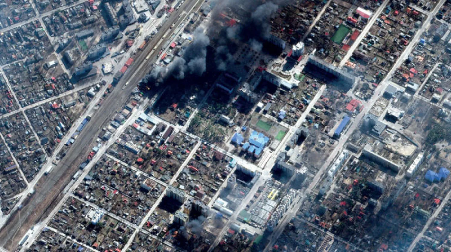 صورة من قمر صناعي تظهر مباني محترقة جراء القصف في كييف أمس (إ.ب.أ)