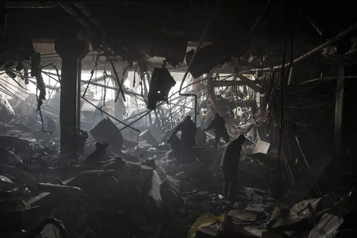 Ukrainian soldiers and firefighters search for people under debris inside a shopping center after shelling, in Kyiv, Ukraine, Monday, March 21, 2022. (AP)