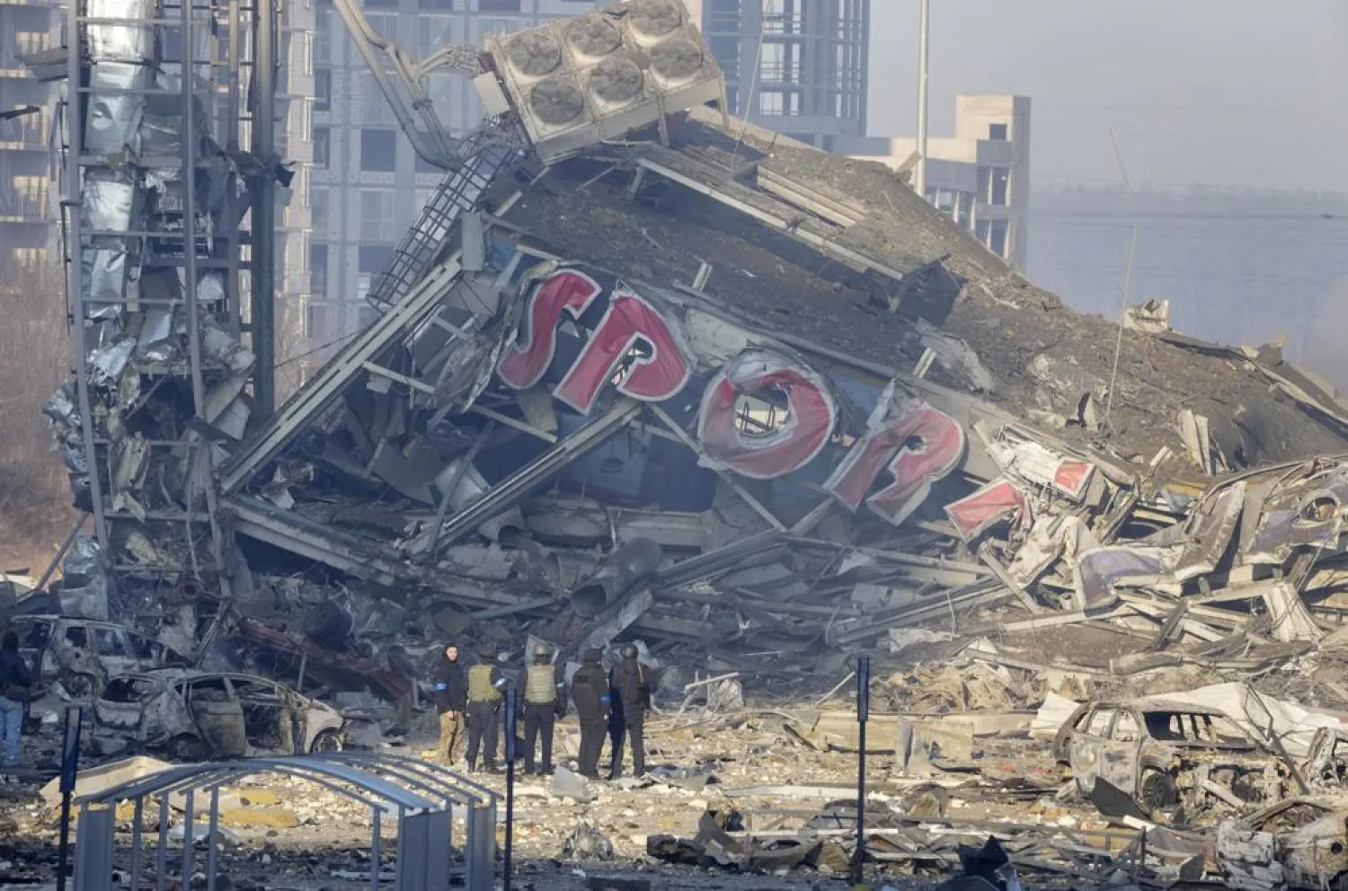 People examine the damage after shelling of a shopping center, in Kyiv, Ukraine, Monday, March 21, 2022. Eight people were killed in the attack. (AP)