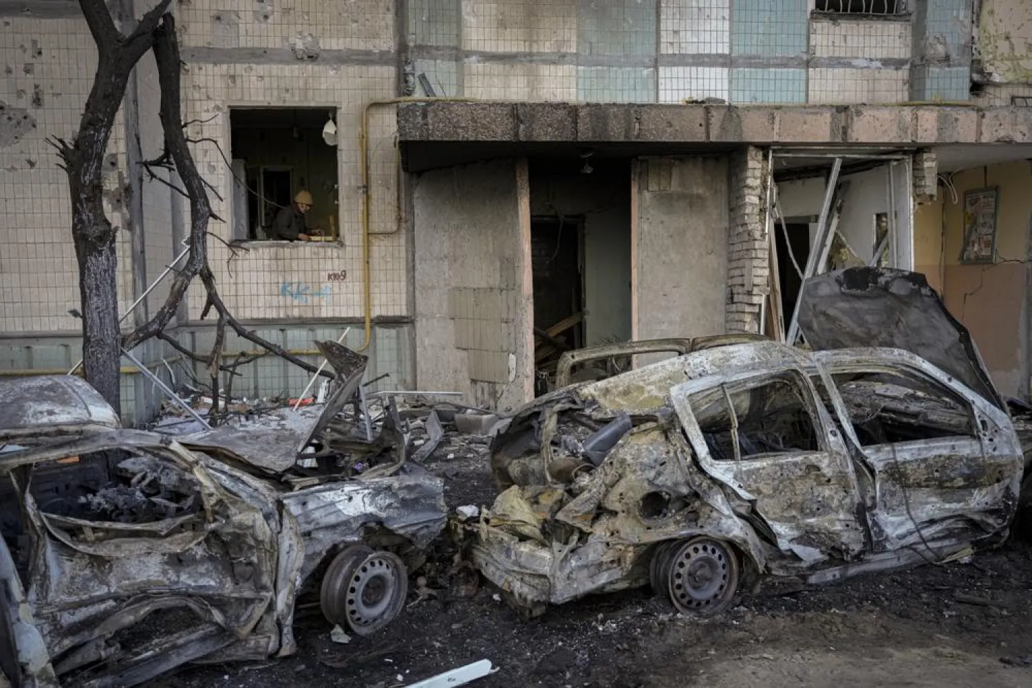 A woman cleans up her kitchen from debris in an apartment block damaged by a bombing the previous day in Kyiv, Ukraine, Monday, March 21, 2022. (AP)