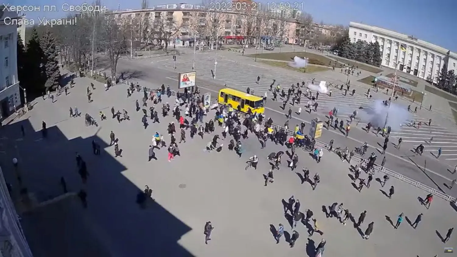 CCTV footage appears to show Russian troops (top, near building) firing stun grenades into a crowd of protesters, some with Ukrainian flags, amid the Russian invasion, along Ushakova Avenue in Kherson, Ukraine March 21, 2022 in this still image from video obtained by REUTERS



