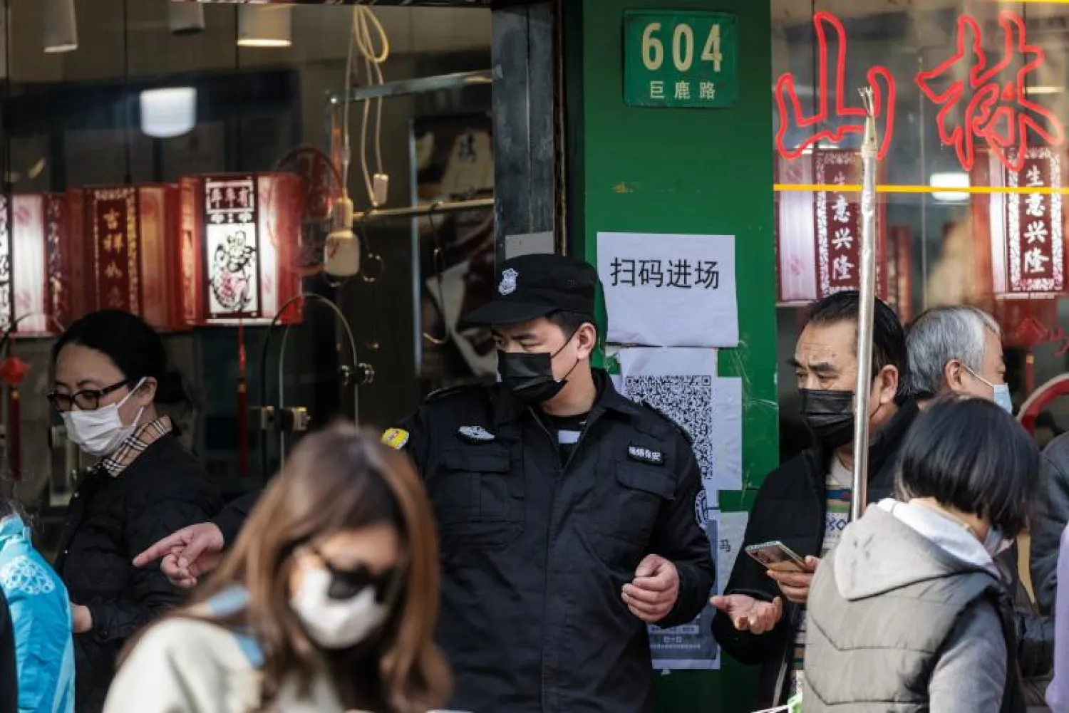 أشخاص يضعون كمامات في أحد أسواق شنغهاي (إ.ب.أ)