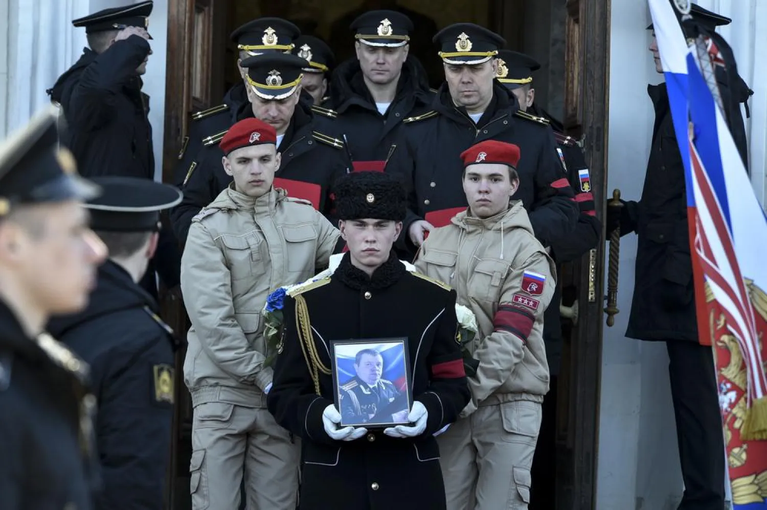 A serviceman carries the photo of Capt. Andrei Paliy, a deputy commander of Russia's Black Sea Fleet, during a farewell ceremony in Sevastopol, Crimea, Wednesday, March 23, 2022. Paliy was killed in action during fighting with Ukrainian forces in the Sea of Azov port of Mariupol. (AP)