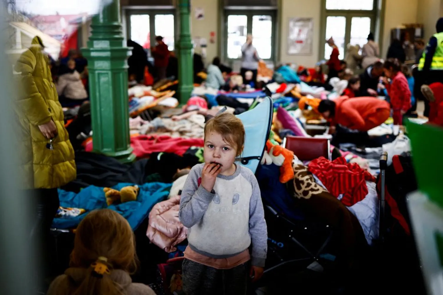 A child eats a cookie as she stands in a temporary accommodation for refugees at the train station, after fleeing Russian invasion of Ukraine, in Przemysl, Poland, March 7, 2022. REUTERS/Yara Nardi/File Photo