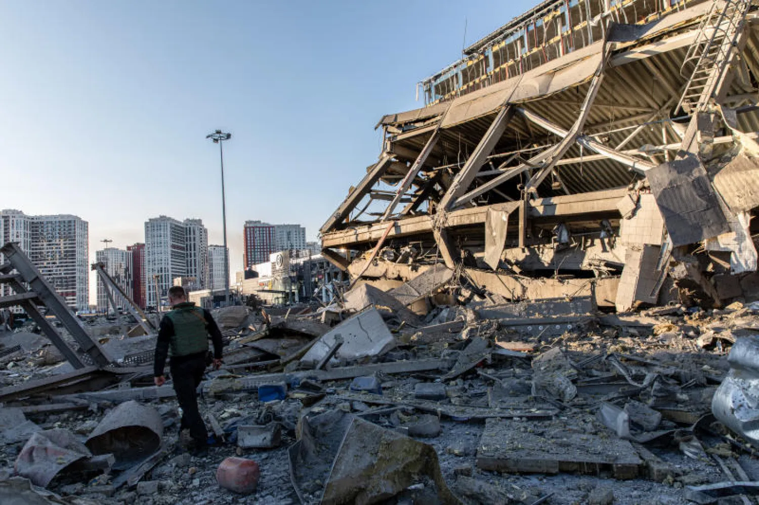 جندي أوكراني خلال حظر التجول في كييف بالقرب من مركز تجاري تعرض للتدمير جراء القصف الروسي (د.ب.أ)