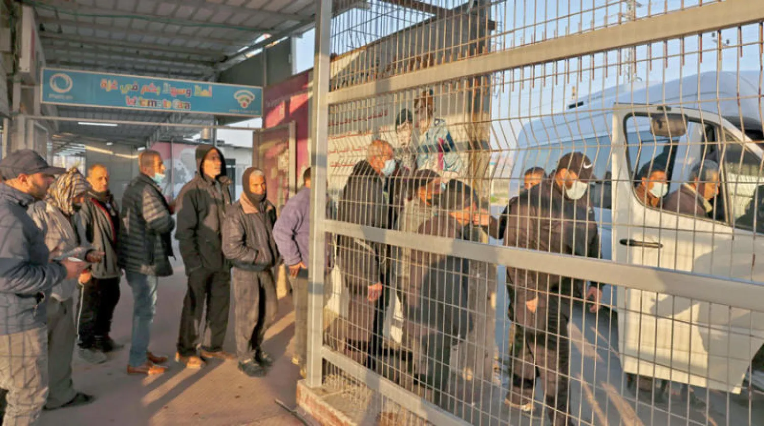 فلسطينيون يصعدون إلى شاحنة صغيرة في معبر في بيت حانون بغزة قبل الوصول إلى إسرائيل فبراير الماضي (أ.ف.ب)