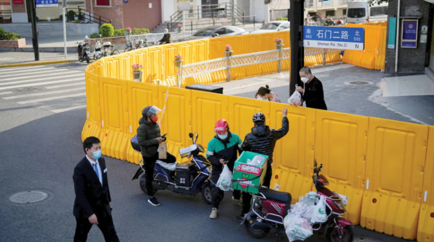 توصيل طعام من خلف سور منطقة منعزلة في شنغهاي (رويترز)