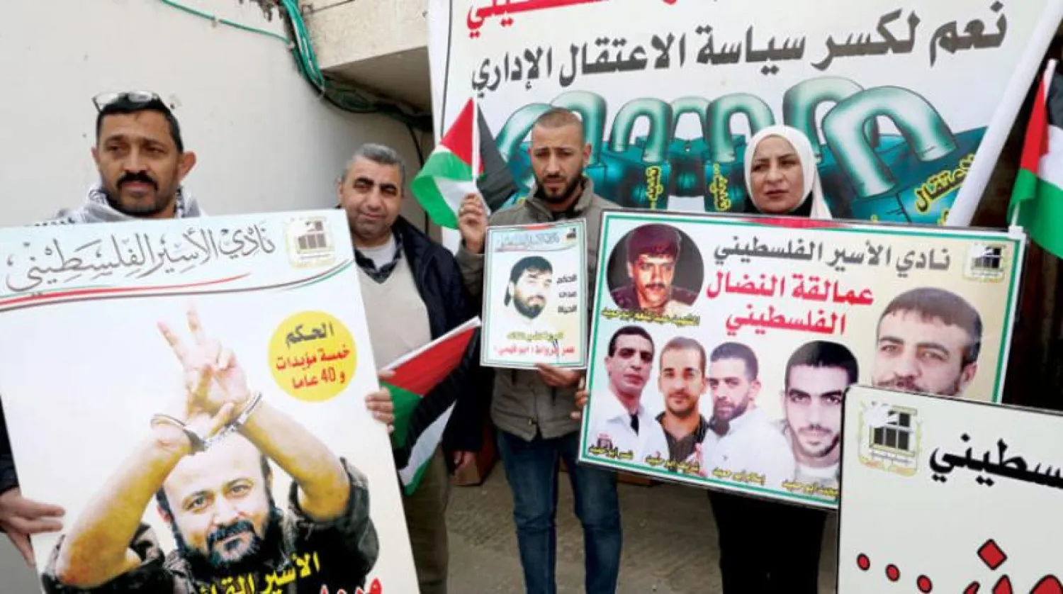 Çocuklarının İsrail hapishanelerinden serbest bırakılmasını talep eden Filistinli aileler El-Halil’deki Kızılhaç Ofisi önünde eylem düzenledi.  (EPA)