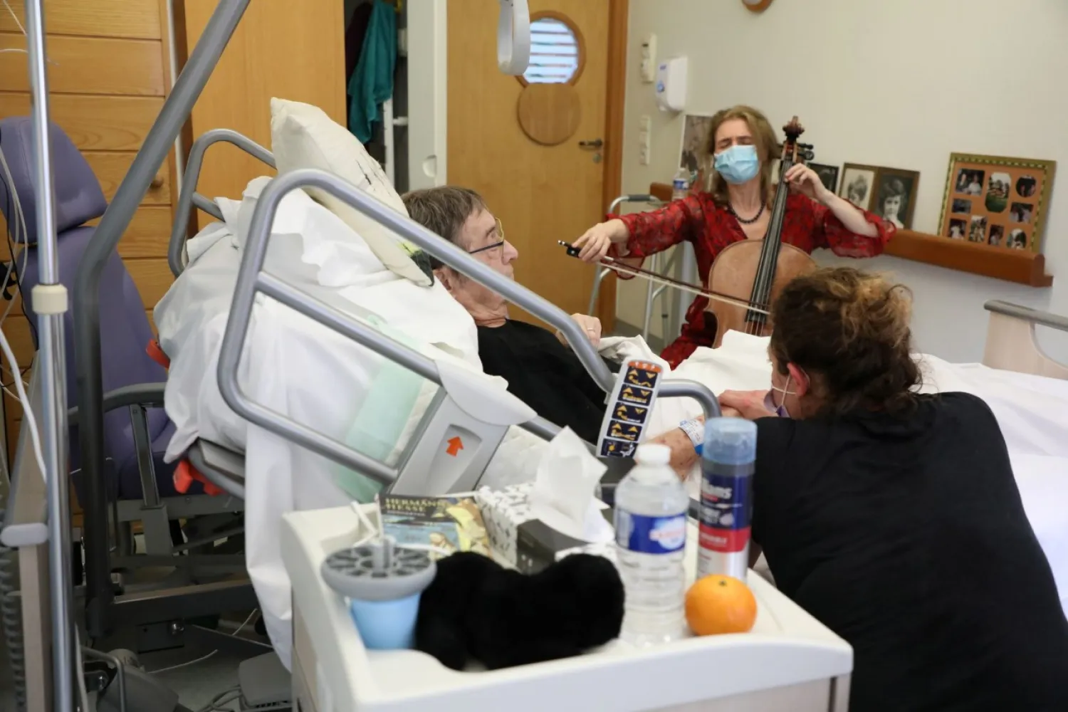 Cellist Claire Oppert plays music to soothe patient Bernard Genin, 79, at end-of-life care home Jeanne Garnier in Paris, France, May 21, 2021. REUTERS/Yiming Woo