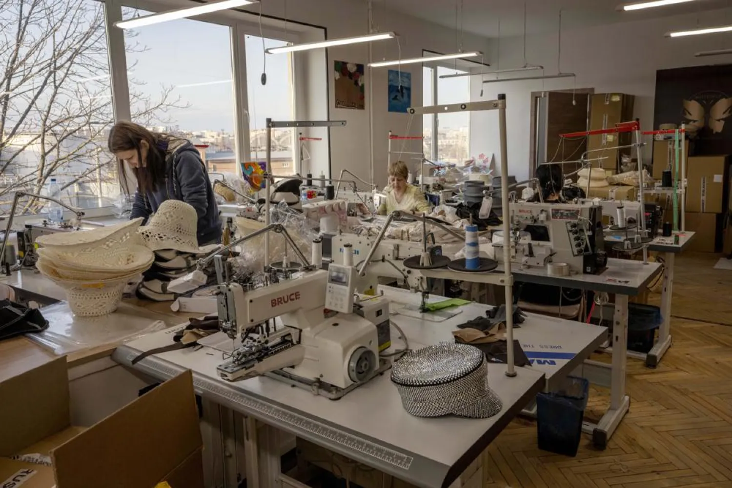 Ukrainian hat makers for high-end designer brand Ruslan Baginskiy "RB", work inside a college classroom turned into a working space for the company after fleeing Kiev, in Lviv, western Ukraine, Friday, March 25, 2022. (AP)