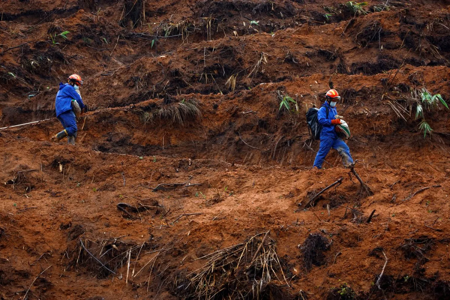Rescue workers walk at the site where a China Eastern Airlines Boeing 737-800 plane flying from Kunming to Guangzhou crashed, in Wuzhou, Guangxi Zhuang Autonomous Region, China March 24, 2022. REUTERS/Carlos Garcia Rawlins/File Photo

