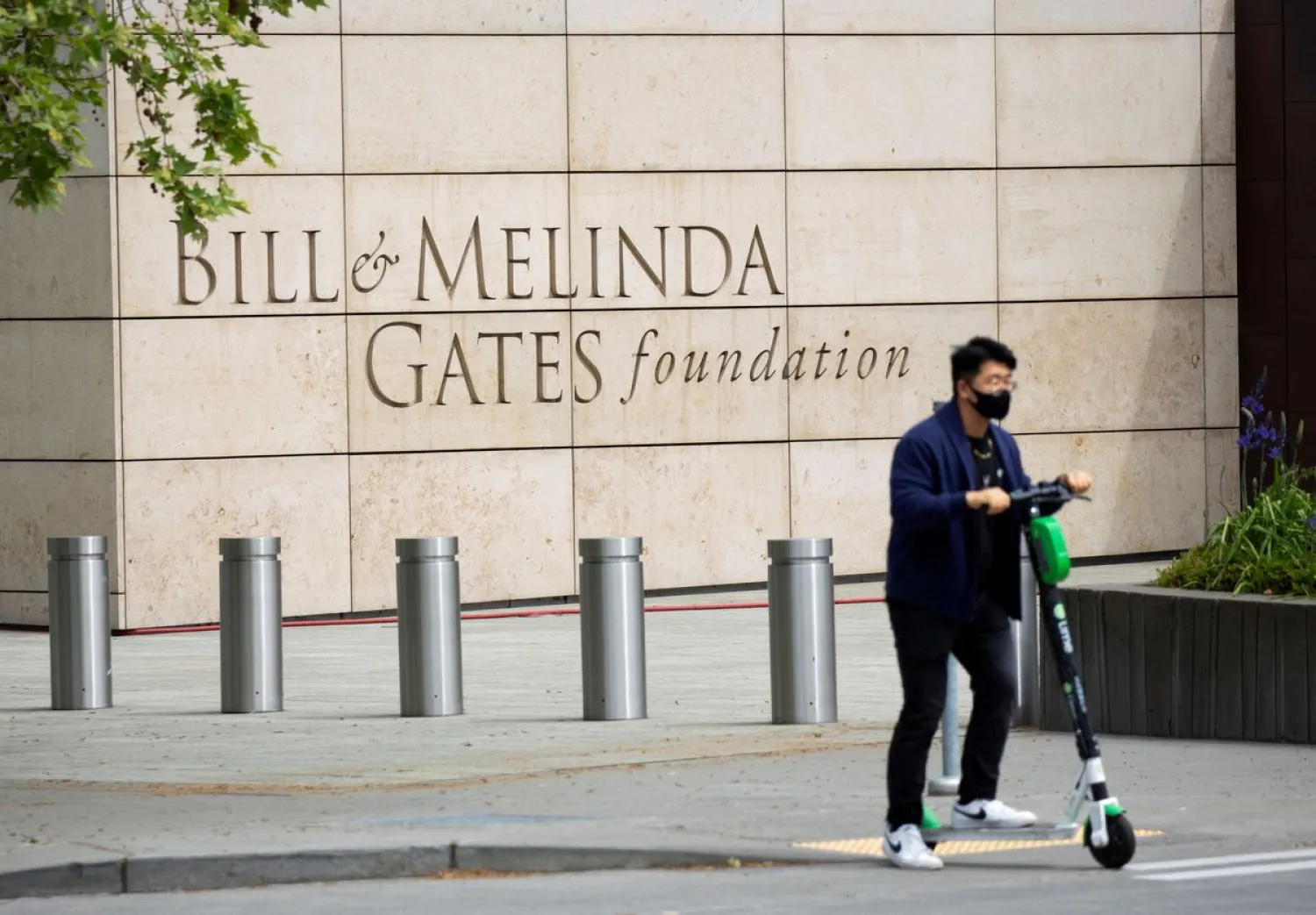 A person passes by on a scooter in front of the Bill & Melinda Gates Foundation in Seattle, Washington, US May 5, 2021. REUTERS/Lindsey Wasson/File Photo


