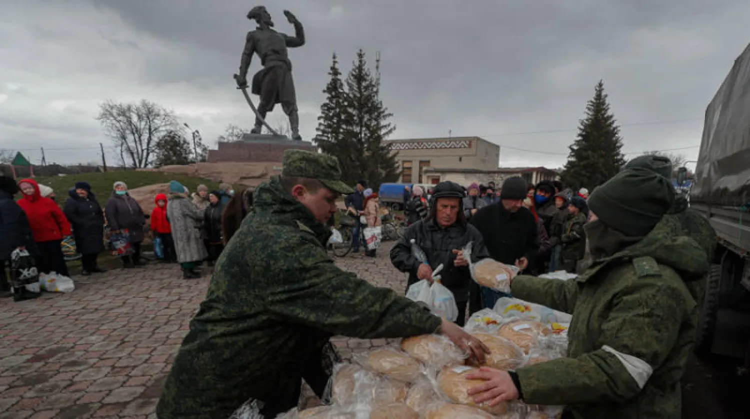 جنود روس وقوات «جمهورية لوغانسك» يوزعون مساعدات إنسانية على المدنيين أمس (إ.ب.أ)