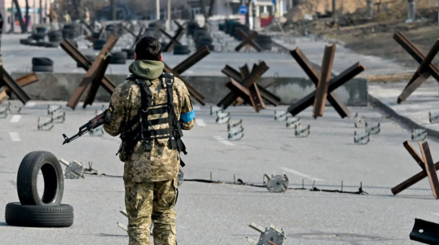 جندي أوكراني يحرس أحد مداخل العاصمة كييف أمس (أ.ف.ب)