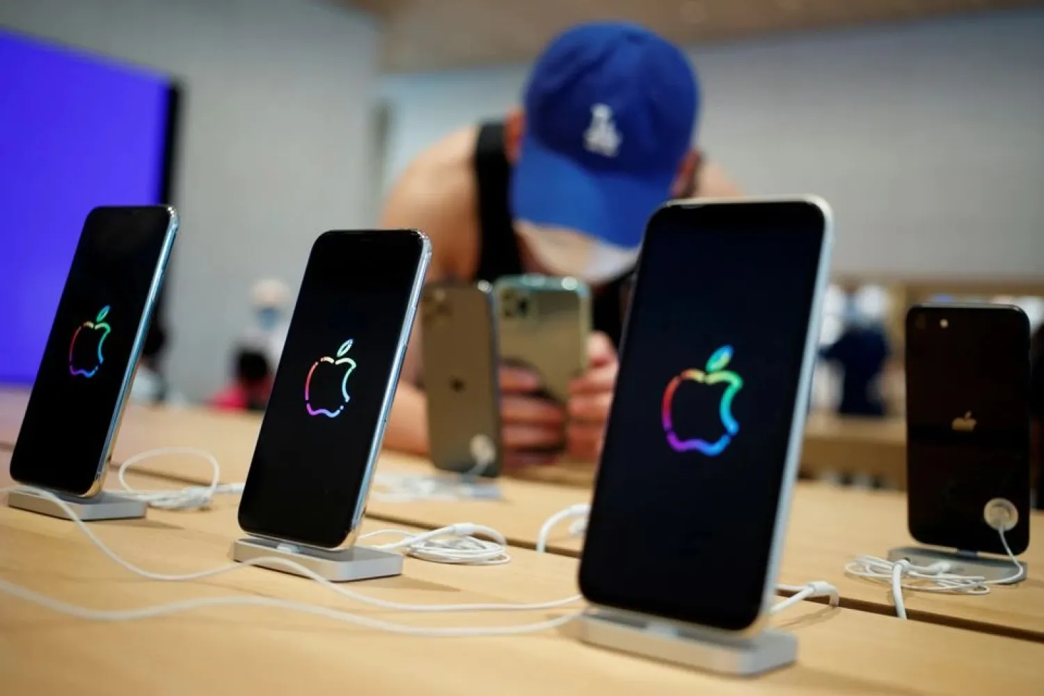 A man takes pictures of iPhones in the new Apple flagship store on its opening day following an outbreak of the coronavirus disease (COVID-19) in Sanlitun in Beijing, China, July 17, 2020. (Reuters)